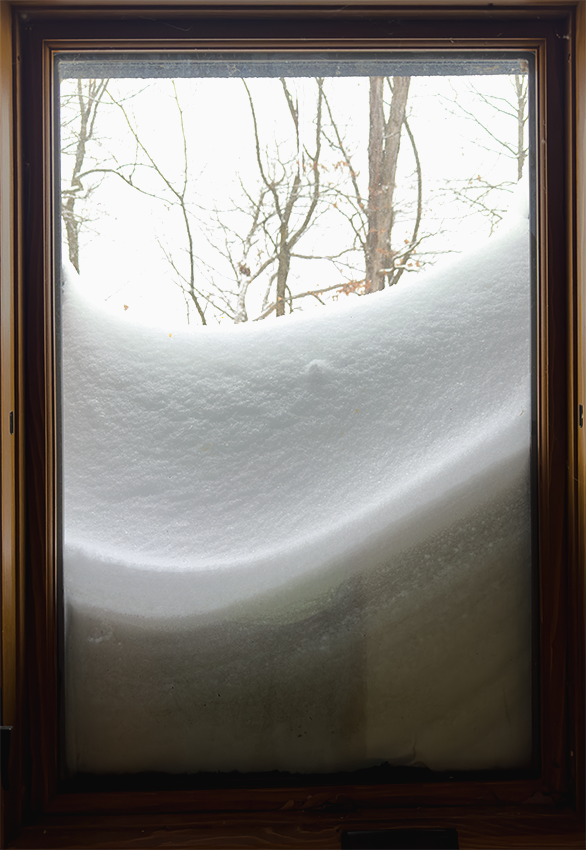 Window well filled with snow